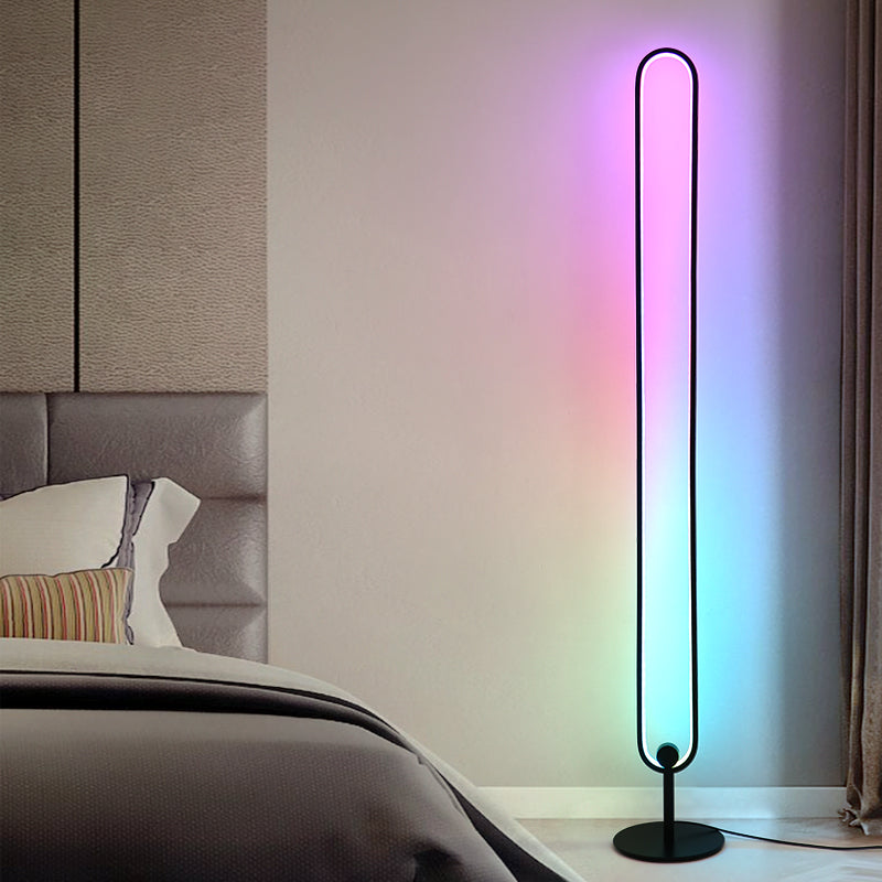 An RGB minimalist lamp illuminating a corner of a bedroom